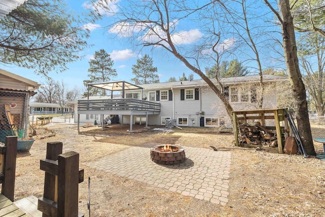 rear view of house featuring a patio area, a fire pit, and a wooden deck