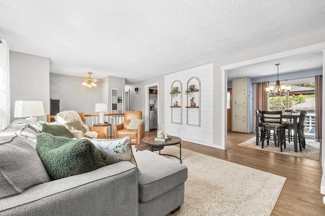 living area featuring a notable chandelier, wood finished floors, and a textured ceiling