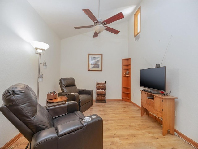 living area featuring visible vents, baseboards, vaulted ceiling, light wood-style floors, and a ceiling fan