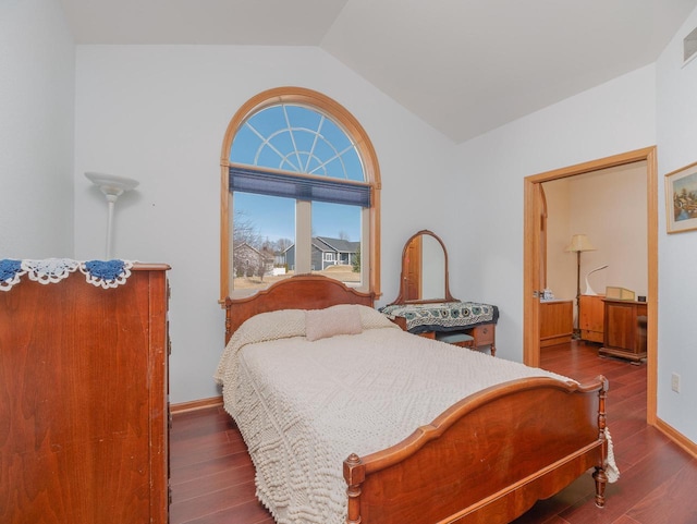 bedroom featuring visible vents, baseboards, lofted ceiling, and wood finished floors