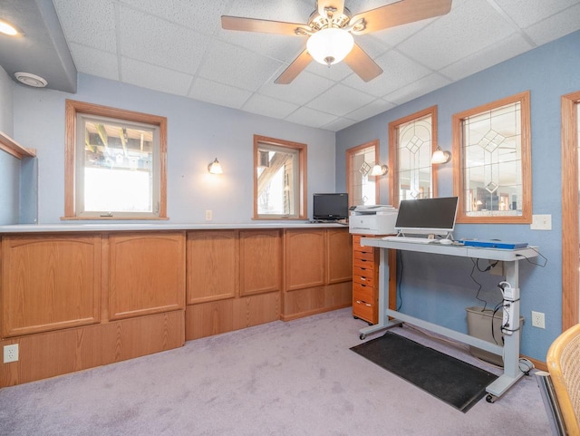 unfurnished office featuring ceiling fan, a paneled ceiling, and light carpet