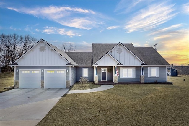 view of front facade with concrete driveway, an attached garage, a lawn, and board and batten siding