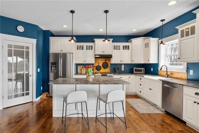 kitchen featuring dark wood-style flooring, appliances with stainless steel finishes, white cabinetry, and a sink