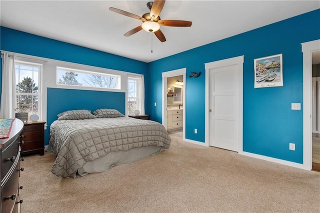 carpeted bedroom featuring connected bathroom, baseboards, and a ceiling fan