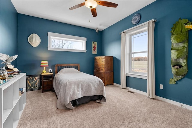 bedroom with carpet flooring, multiple windows, baseboards, and ceiling fan