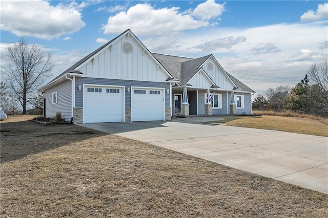 craftsman-style house with stone siding, board and batten siding, driveway, and a garage