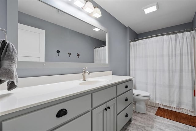 full bathroom featuring vanity, a shower with shower curtain, and toilet