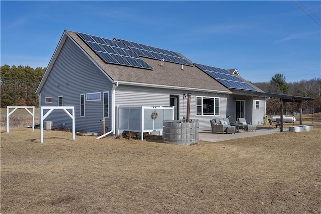 rear view of property with a patio, cooling unit, roof with shingles, outdoor lounge area, and solar panels