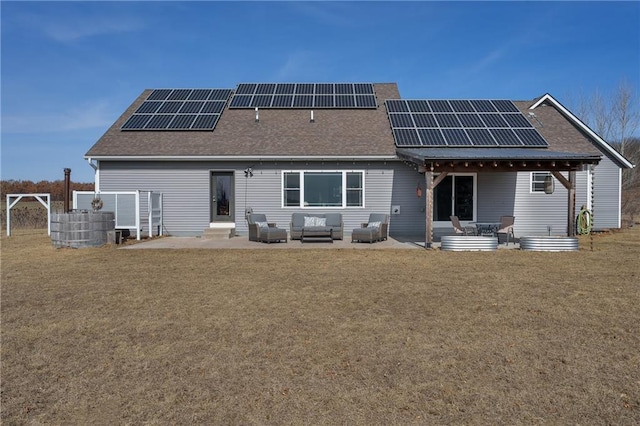 back of house with solar panels, a yard, a patio area, and a shingled roof