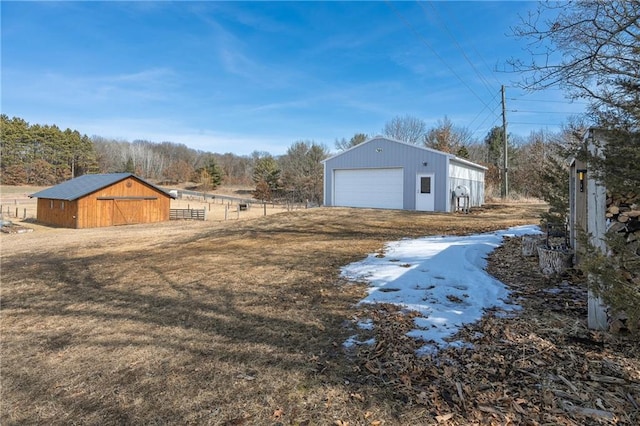 view of yard featuring an outbuilding, a garage, an outdoor structure, and fence