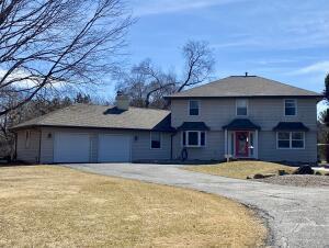 traditional-style house with a front lawn, an attached garage, and driveway