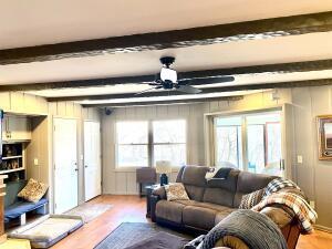 living room featuring beam ceiling and wood finished floors