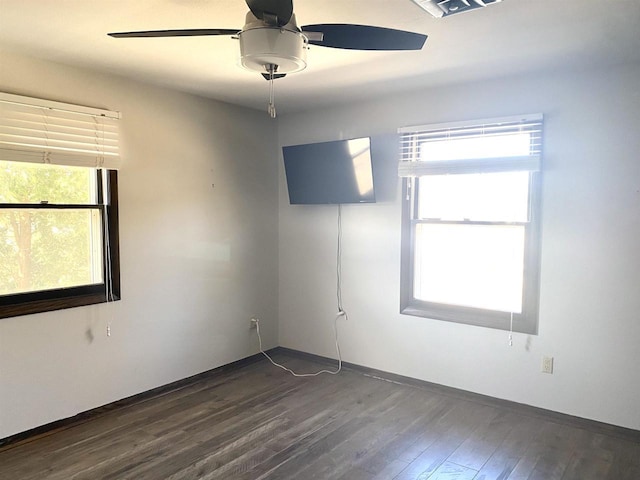 empty room with a ceiling fan, dark wood-style flooring, and baseboards