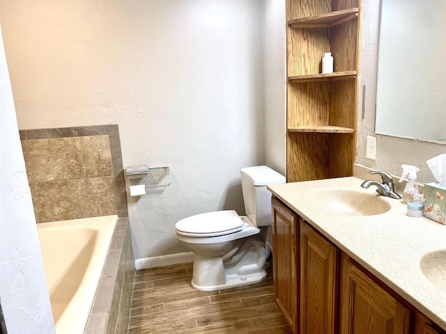 bathroom featuring wood tiled floor, double vanity, a sink, toilet, and a washtub