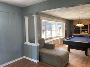 recreation room with decorative columns, wood finished floors, billiards, and a decorative wall