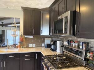 kitchen with decorative backsplash, stainless steel appliances, and light countertops