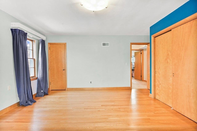 unfurnished room with light wood-style flooring, baseboards, and visible vents