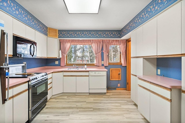 kitchen with wallpapered walls, a sink, black microwave, range with electric stovetop, and dishwasher