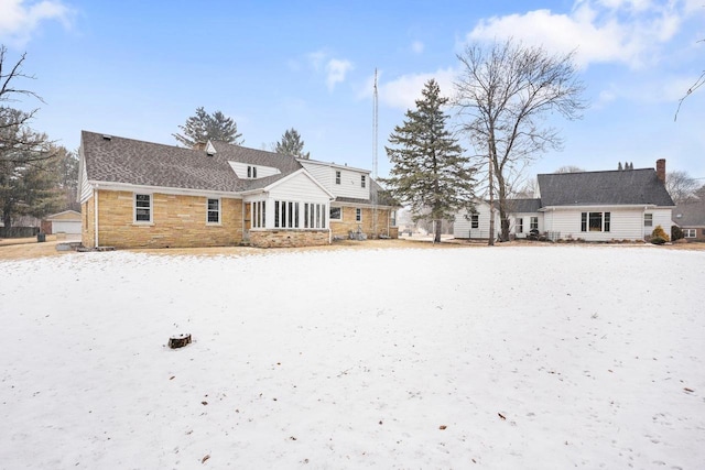 rear view of house featuring a chimney and a sunroom