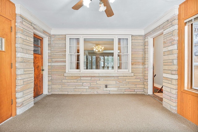 unfurnished sunroom featuring ceiling fan with notable chandelier