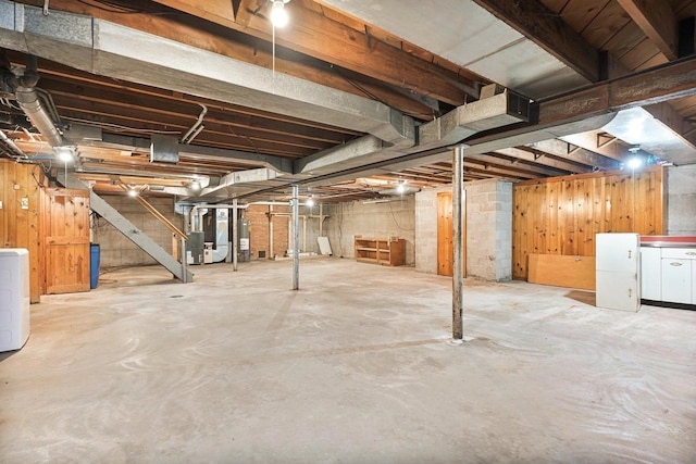 unfinished below grade area with stairway, heating unit, and water heater