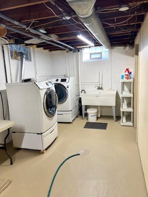 laundry room with laundry area, washing machine and dryer, and a sink