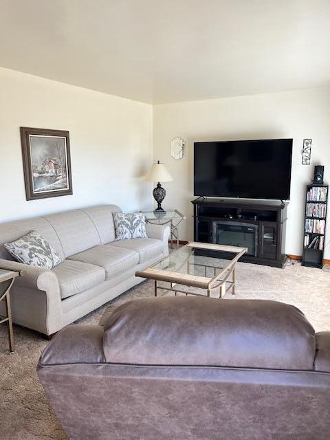 carpeted living room featuring baseboards