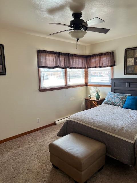 bedroom featuring multiple windows, baseboards, dark carpet, and a textured ceiling