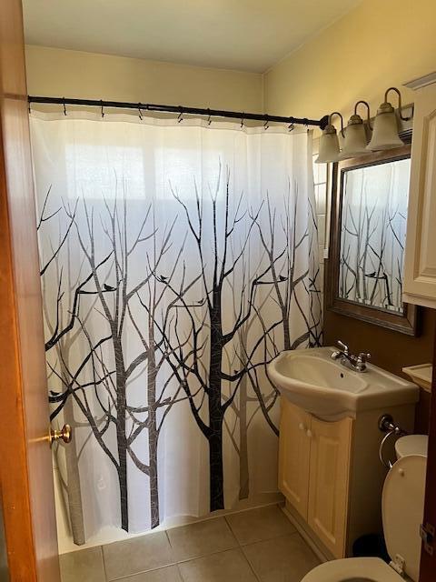 bathroom featuring tile patterned floors, toilet, a shower with shower curtain, and vanity