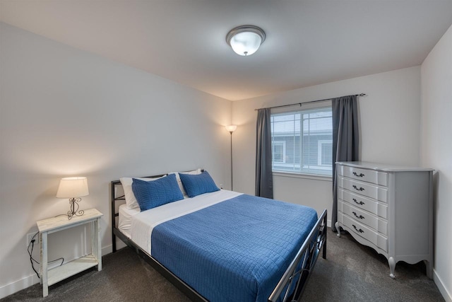 bedroom featuring dark carpet and baseboards