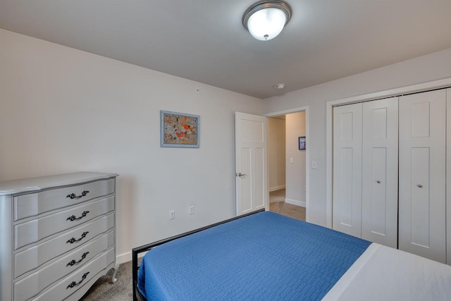 bedroom with carpet, baseboards, and a closet