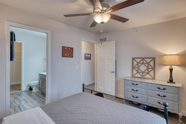 bedroom with connected bathroom, visible vents, baseboards, and ceiling fan