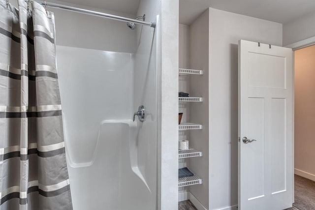 bathroom featuring a shower with curtain and baseboards