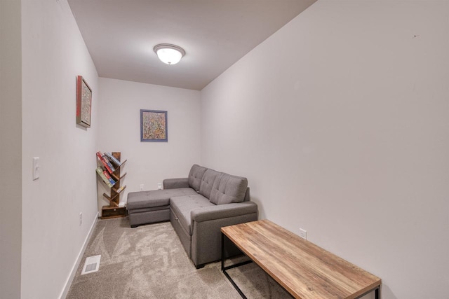 living area featuring visible vents, baseboards, and light colored carpet