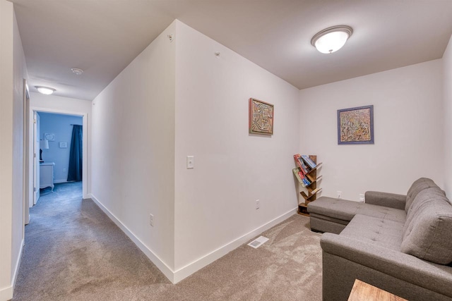 carpeted living area featuring baseboards and visible vents