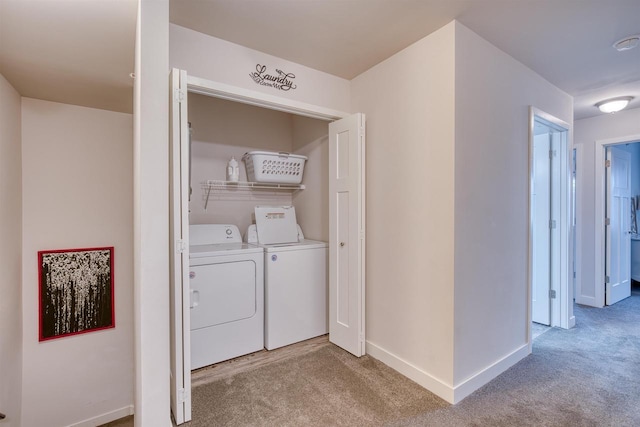 laundry room with laundry area, washer and dryer, light colored carpet, and baseboards