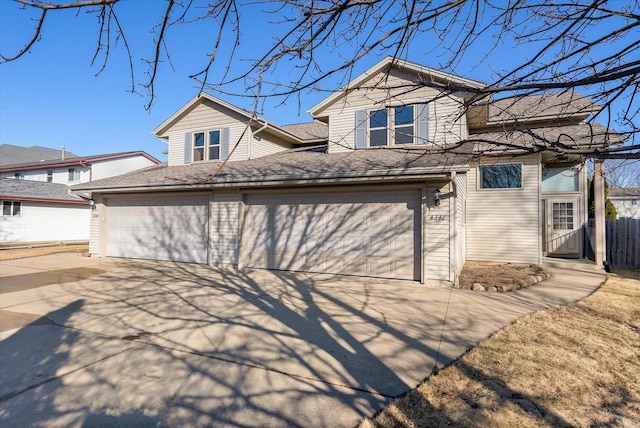 exterior space with a garage, roof with shingles, driveway, and fence