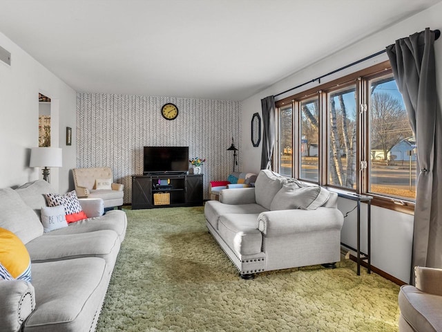 living area with wallpapered walls, an accent wall, baseboards, and carpet floors