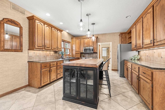 kitchen with visible vents, brown cabinets, stainless steel appliances, and open shelves