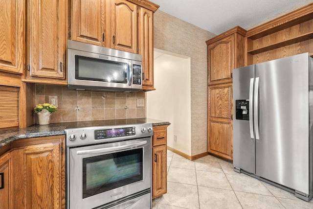 kitchen featuring backsplash, appliances with stainless steel finishes, light tile patterned flooring, brown cabinetry, and open shelves