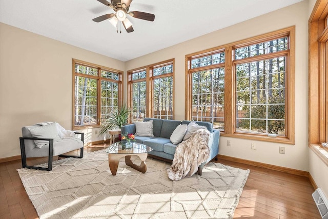 sunroom featuring visible vents, a healthy amount of sunlight, and a ceiling fan