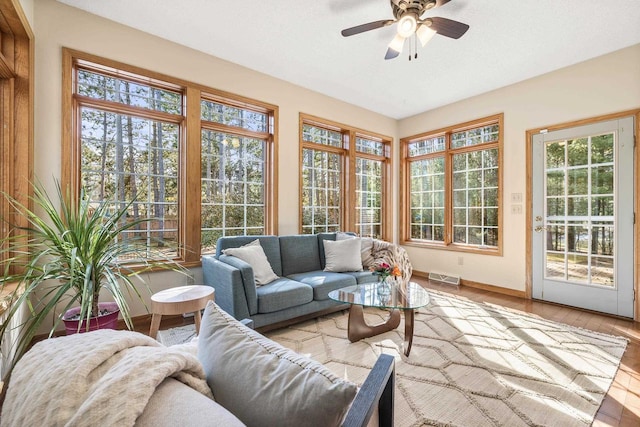 sunroom / solarium featuring visible vents, plenty of natural light, and a ceiling fan