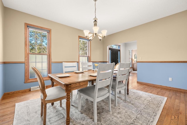 dining area featuring a chandelier, visible vents, baseboards, and light wood-style floors