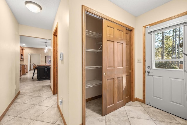 interior space with light tile patterned floors and baseboards