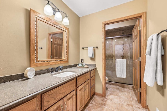 bathroom with baseboards, toilet, a stall shower, tile patterned floors, and vanity