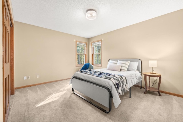 carpeted bedroom featuring baseboards and a textured ceiling