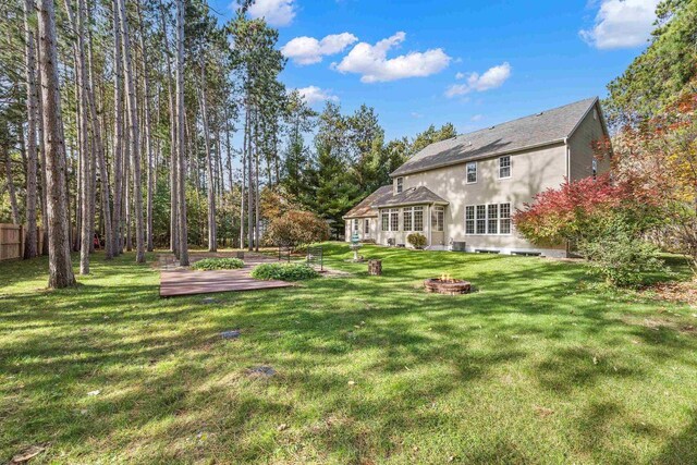 view of yard with a wooden deck and a fire pit