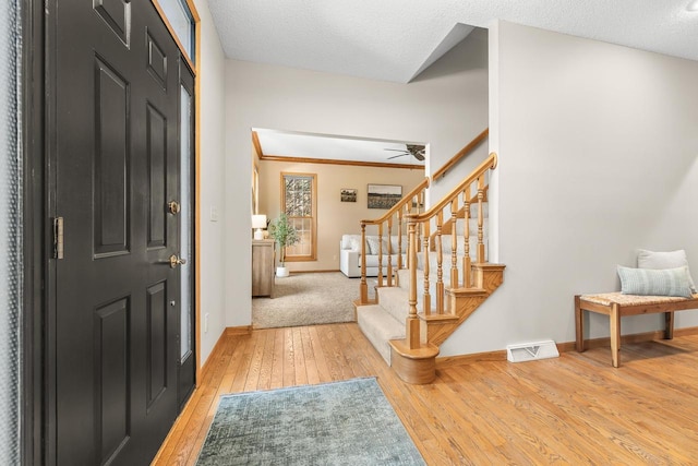 entryway featuring stairway, light wood-style flooring, visible vents, and baseboards