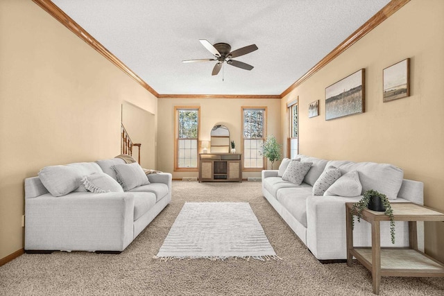 living room featuring a ceiling fan, baseboards, a textured ceiling, crown molding, and light carpet