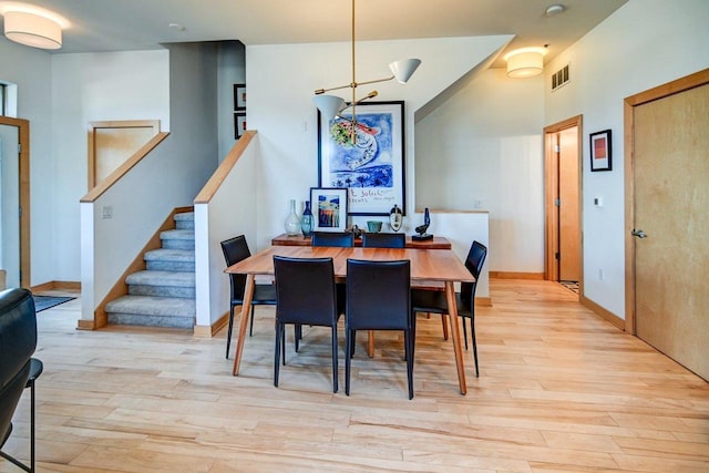 dining area with stairway, visible vents, light wood-type flooring, and baseboards